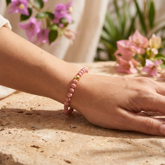 Model draagt handgemaakte rhodoniet armband 4mm van Beaditude om de pols