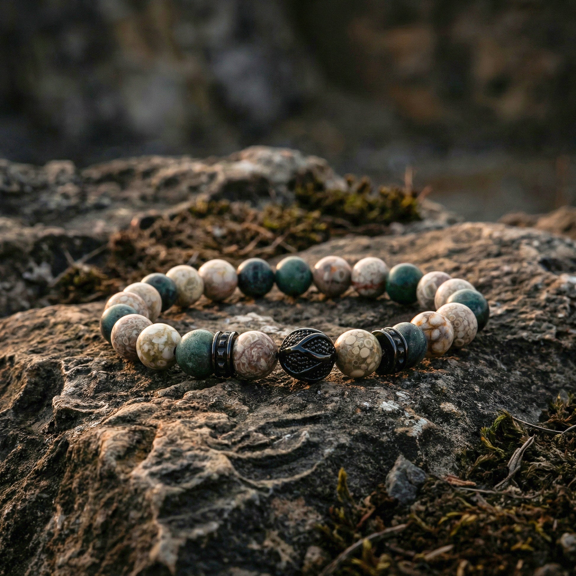 Elastische edelsteen armband met zwarte rvs spacers en bewerkte kraal. met 8mm edelsteen kralen serpentijn en jaspis.