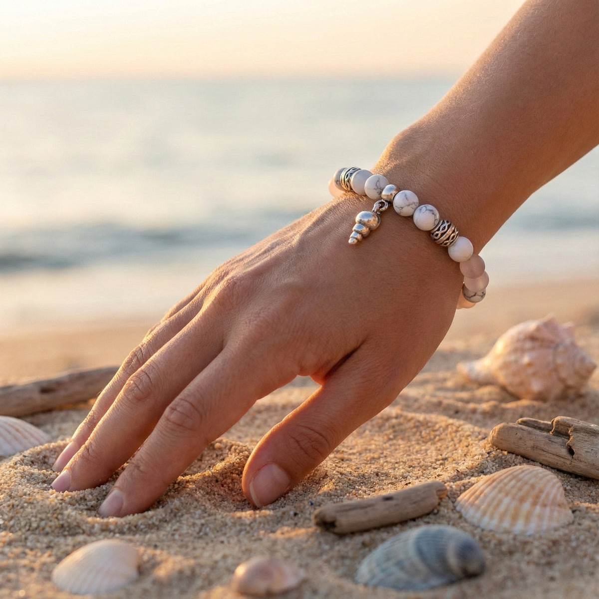 Elastische edelsteen armband met de kralen howliet en rozenkwarts en dq zilveren onderdelen en schelpje bedel