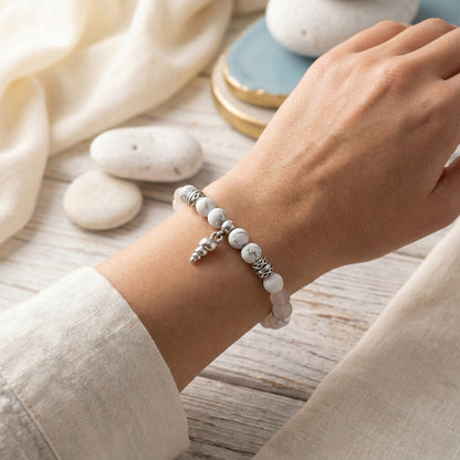 Elastische edelsteen armband met de kralen howliet en rozenkwarts en dq zilveren onderdelen en schelpje bedel